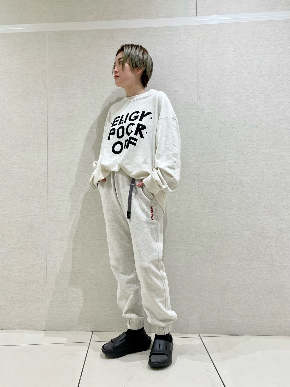 グレー系のスウェットパンツ、ホワイト系のTシャツ/カットソー、ブラック系のサンダルを着用したレディースの春コーディネートの1枚目の写真