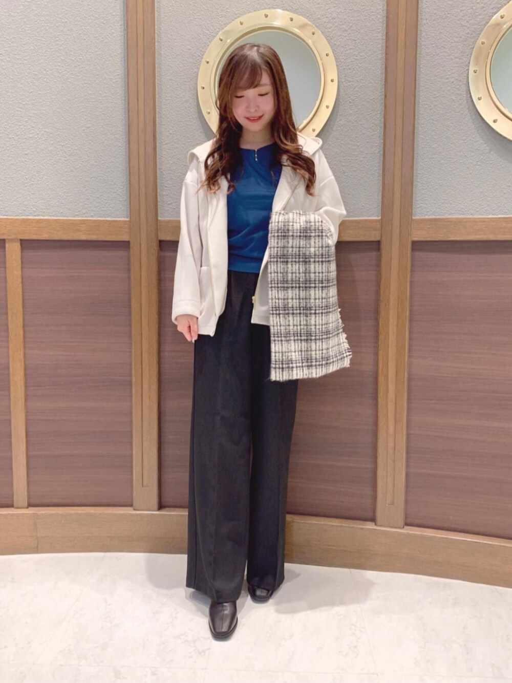 ブラック系のブーツ、ホワイト系のその他アウター、ブルー系のニット/セーターを着用したレディースの冬コーディネートの1枚目の写真