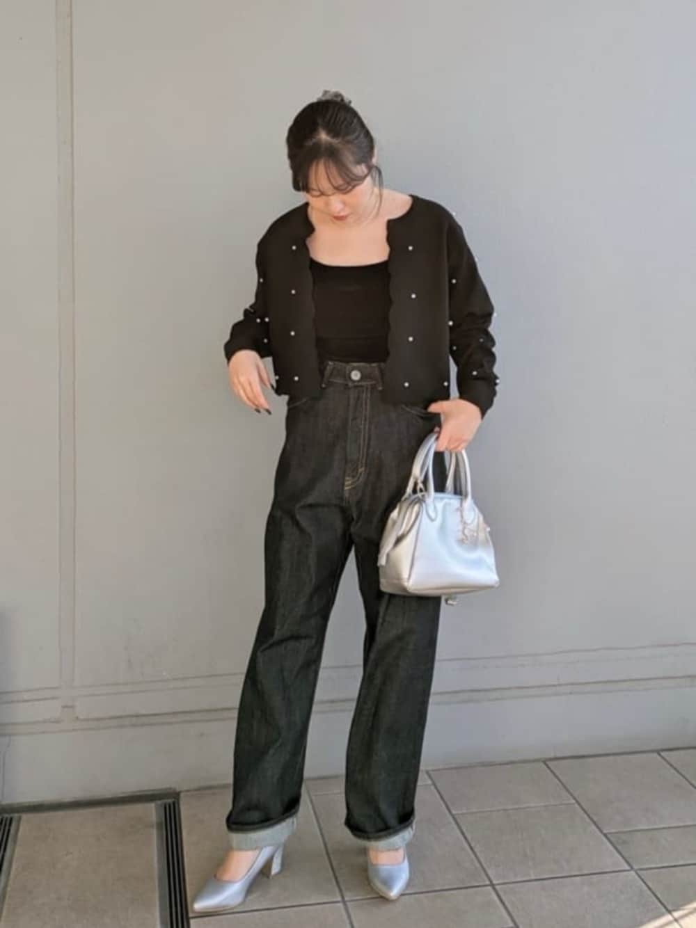 シルバー系のパンプス、シルバー系のハンドバッグ、ブラック系のカーディガン/ボレロを着用したレディースの冬コーディネートの1枚目の写真