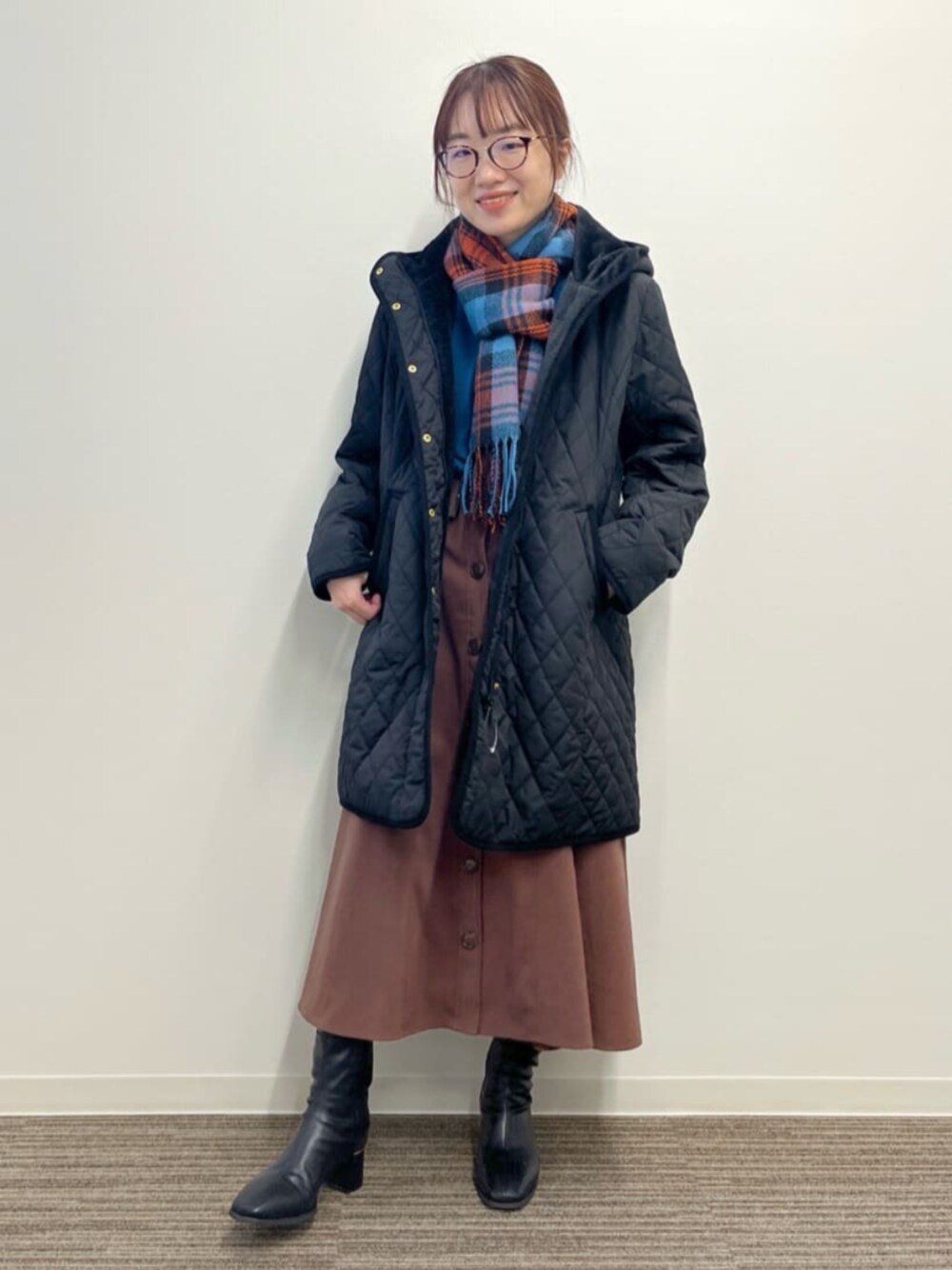 ブラック系のその他アウター、ブルー系のニット/セーター、ブラウン系のスカートを着用したレディースの冬コーディネートの1枚目の写真