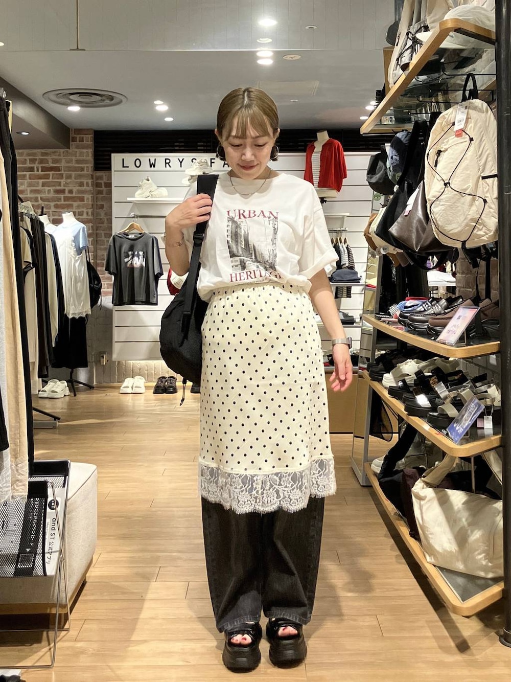 ブラック系のデニムパンツ、ブラック系のバックパック/リュック、ホワイト系のスカートを着用したレディースの夏コーディネートの1枚目の写真