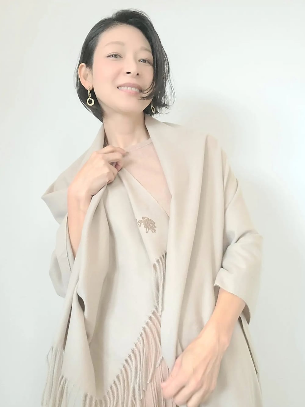 ベージュ系のストール/ショールを着用したレディースの秋コーディネートの1枚目の写真