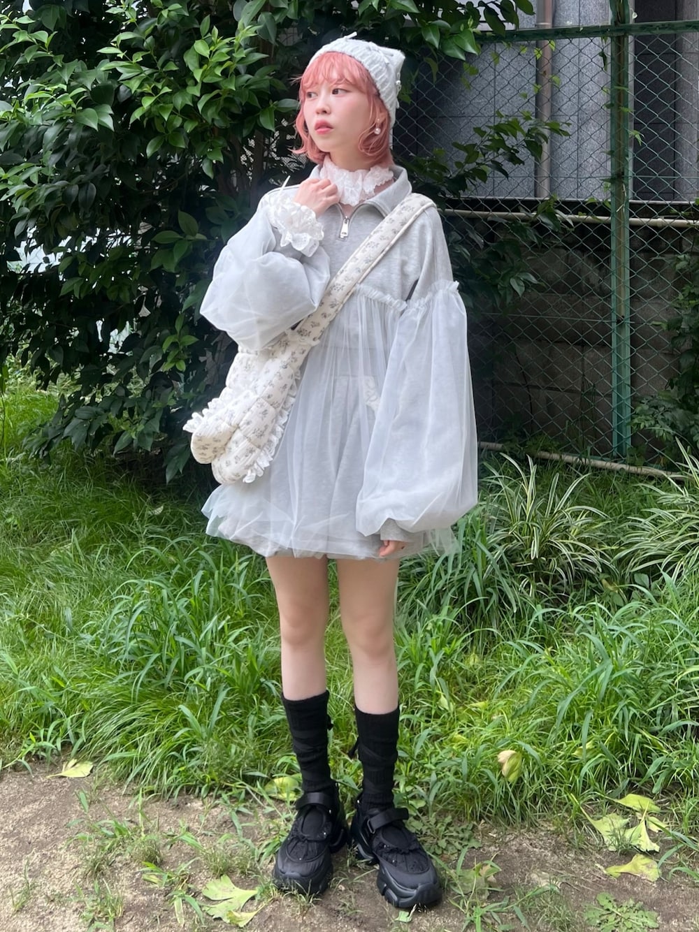 グレー系のスウェット、ピンク系のニット/セーター、ブルー系のショルダーバッグを着用したレディースの秋コーディネートの1枚目の写真