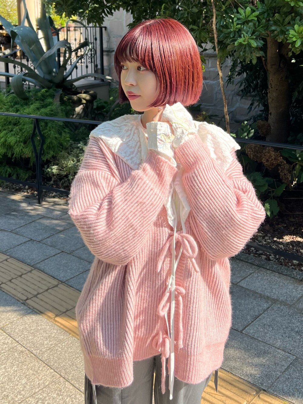 ホワイト系のTシャツ/カットソー、グレー系のスラックス、ピンク系のカーディガン/ボレロを着用したレディースの秋コーディネートの1枚目の写真