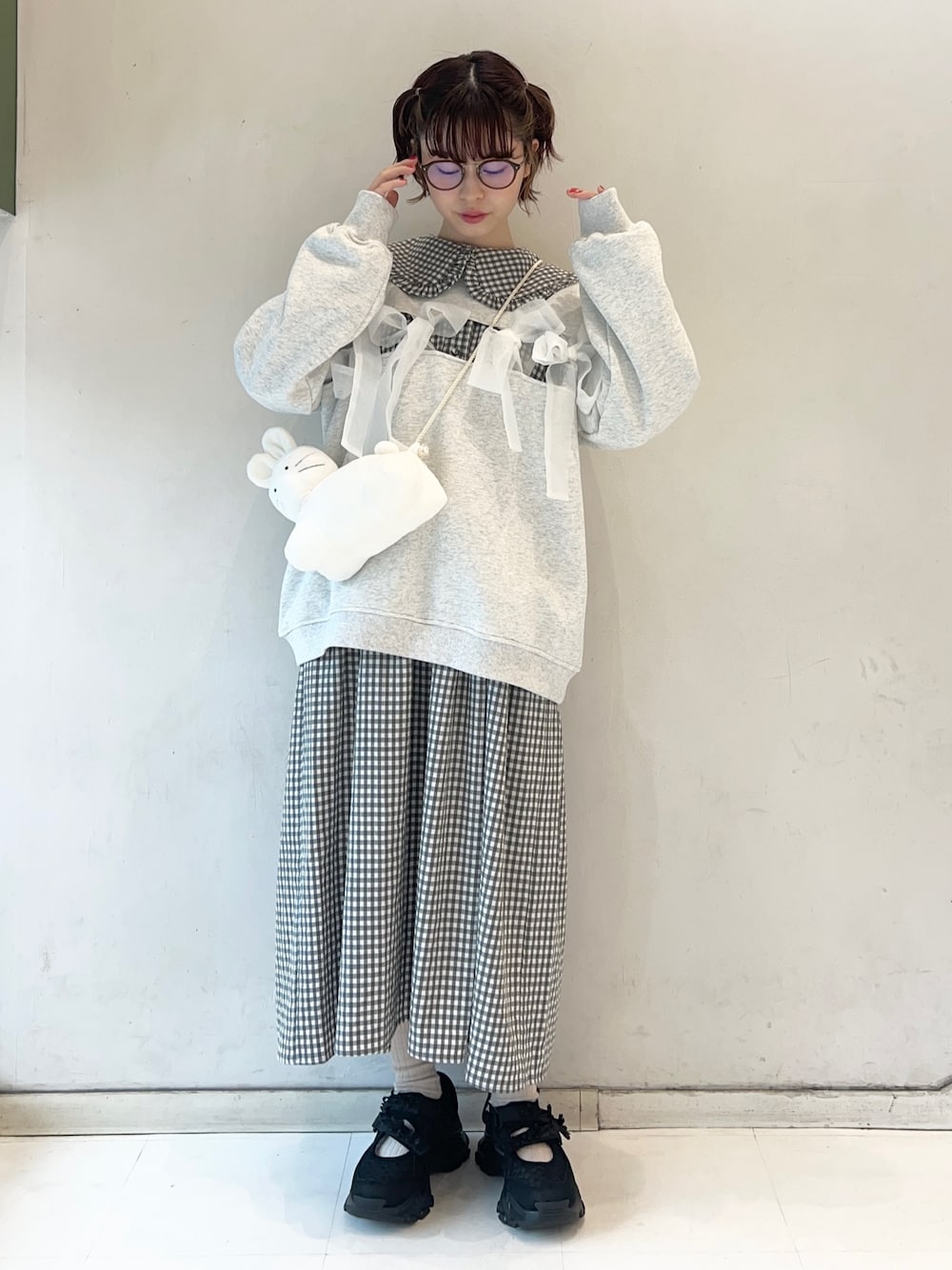 ブラック系のワンピース、ブラック系のスニーカー、ホワイト系のショルダーバッグを着用したレディースの冬コーディネートの1枚目の写真