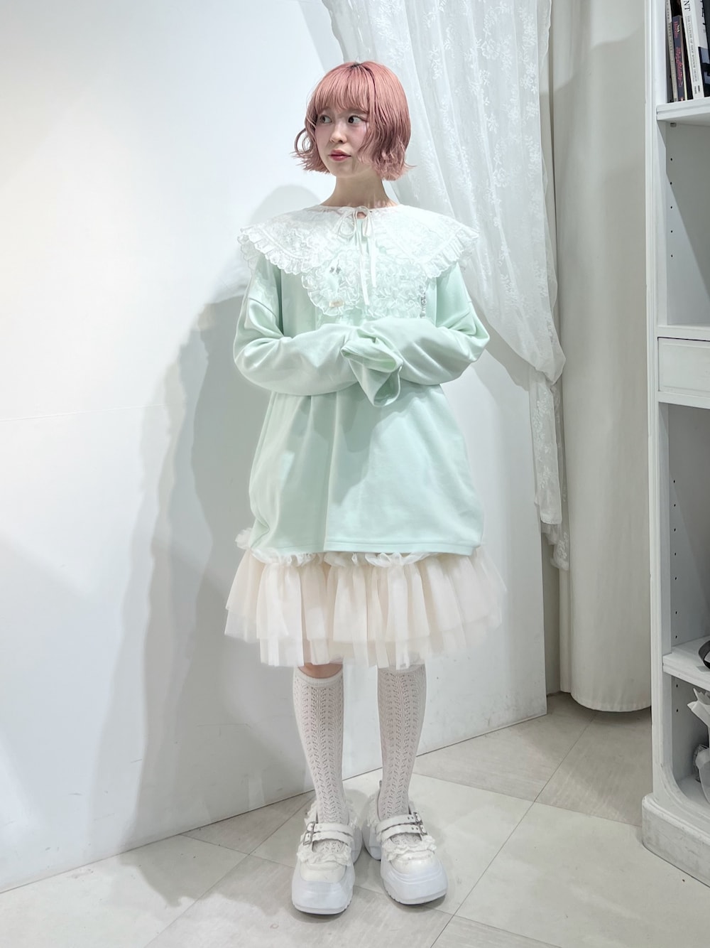 グリーン系のTシャツ/カットソー、ピンク系のスカート、ホワイト系のスニーカーを着用したレディースの夏コーディネートの1枚目の写真