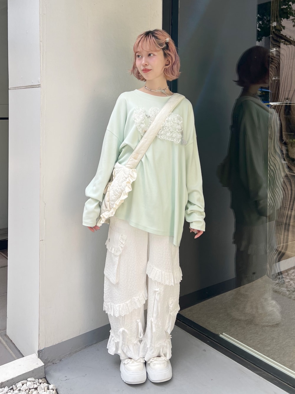 グリーン系のTシャツ/カットソー、ホワイト系のショルダーバッグ、ホワイト系のカーゴパンツを着用したレディースの夏コーディネートの1枚目の写真