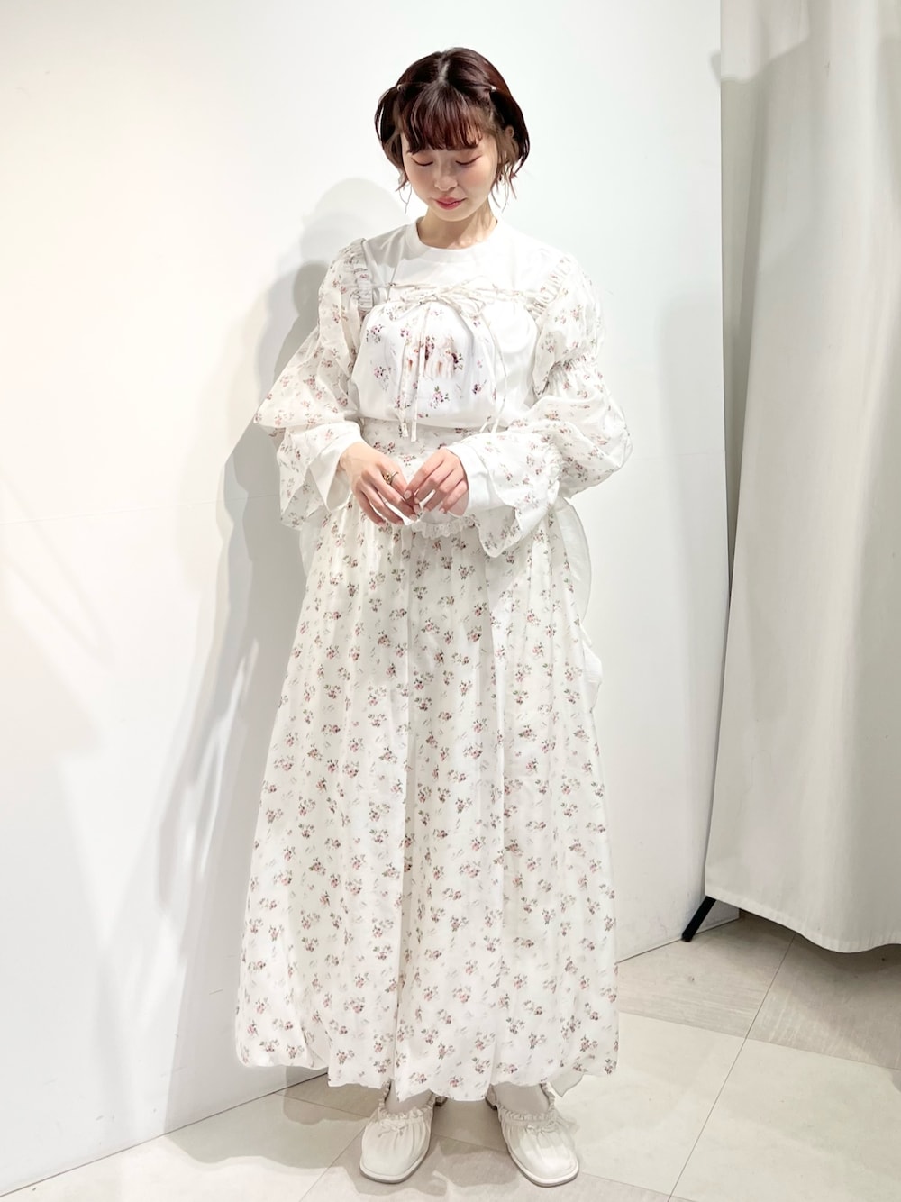 ホワイト系のパンプス、ホワイト系のカーディガン/ボレロ、ホワイト系のTシャツ/カットソーを着用したレディースの春コーディネートの1枚目の写真