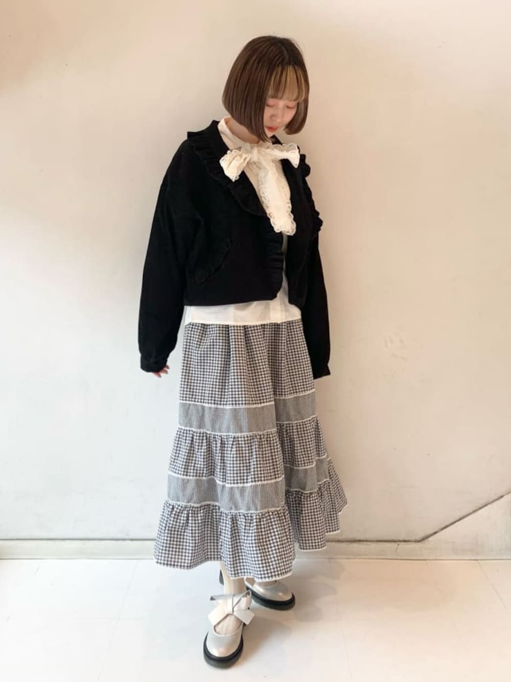 ホワイト系のパンプス、ブラック系のその他アウター、ホワイト系のシャツ/ブラウスを着用したレディースの冬コーディネートの1枚目の写真