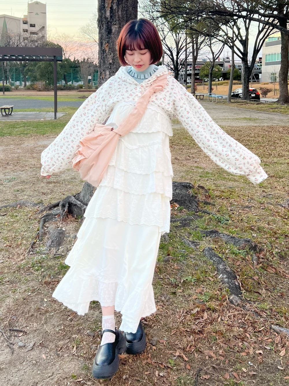 ホワイト系のワンピース、その他のカーディガン/ボレロ、ピンク系のショルダーバッグを着用したレディースの冬コーディネートの1枚目の写真