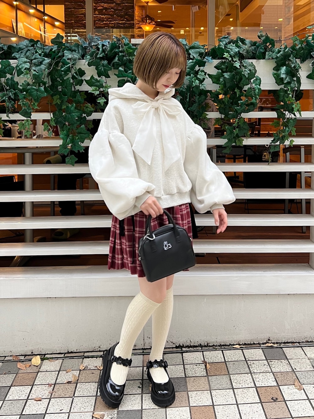 ブラック系のローファー、ホワイト系のパーカー、ブラック系のボストンバッグを着用したレディースの冬コーディネートの1枚目の写真