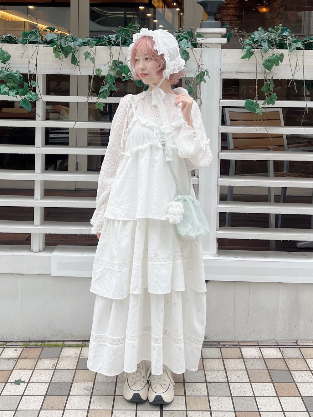 ホワイト系のTシャツ/カットソー、グリーン系のハンドバッグ、ホワイト系のワンピースを着用したレディースの冬コーディネートの1枚目の写真