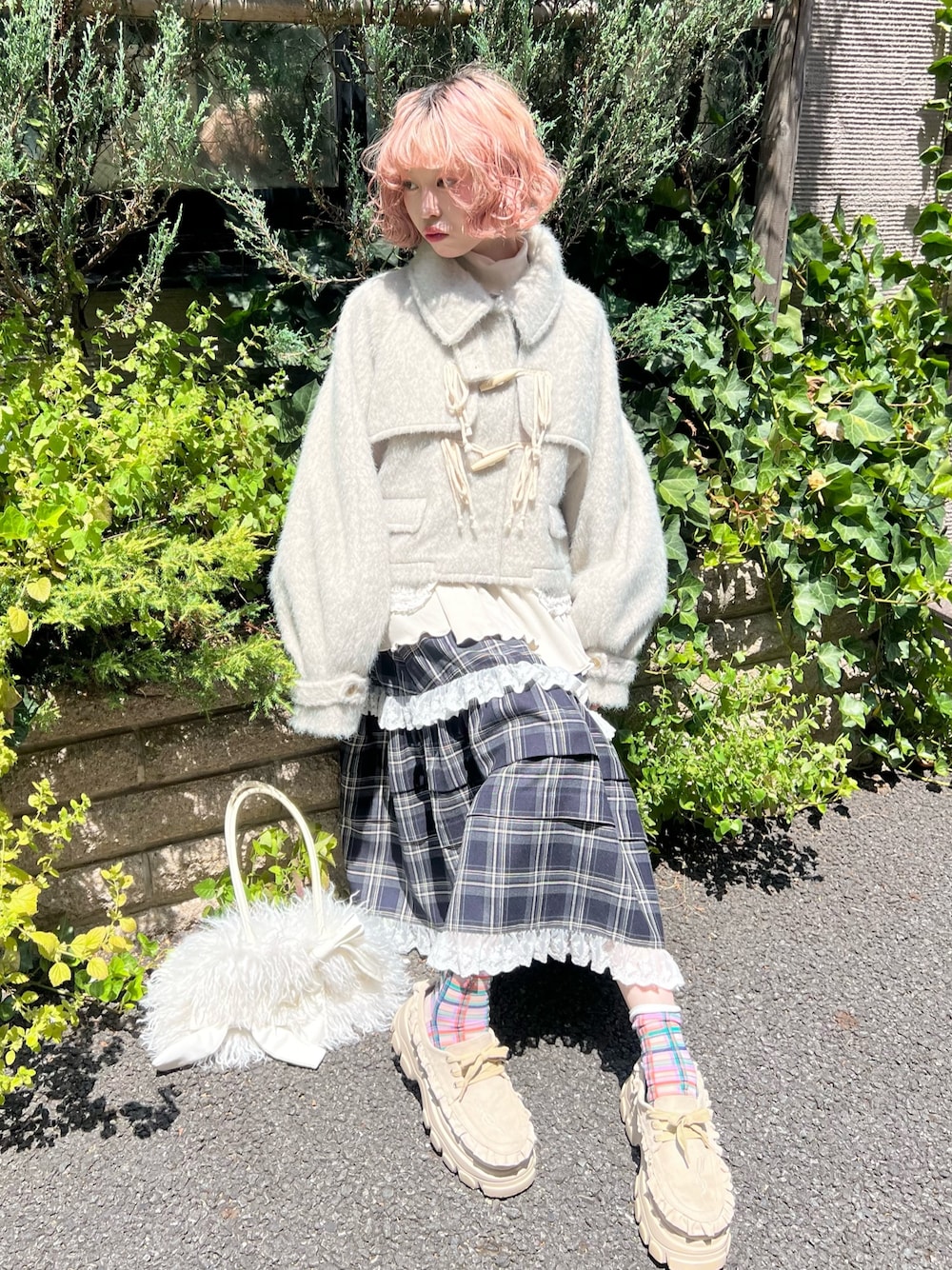 グリーン系のダッフルコート、ブルー系のスカート、ベージュ系のローファーを着用したレディースの夏コーディネートの1枚目の写真