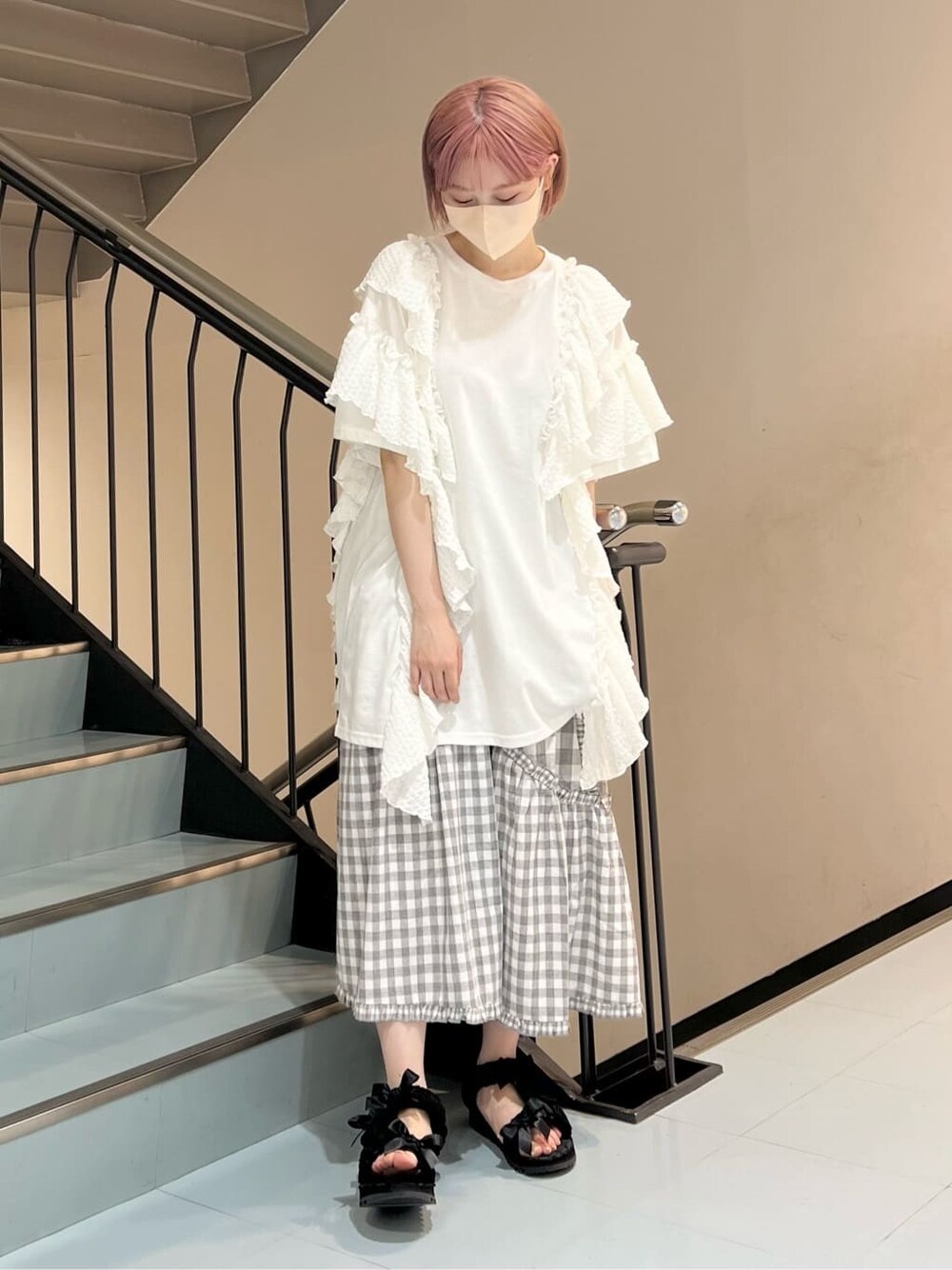 ホワイト系のチュニック、グレー系のスカート、ブラック系のサンダルを着用したレディースの夏コーディネートの1枚目の写真