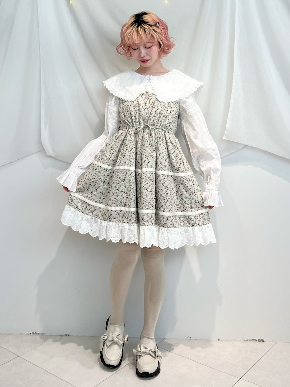 ホワイト系のシャツ/ブラウス、グリーン系のワンピース、ホワイト系のスニーカーを着用したレディースの冬コーディネートの1枚目の写真