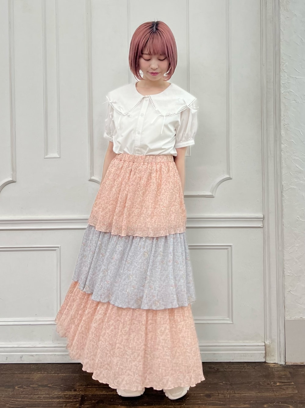 ホワイト系のシャツ/ブラウス、ピンク系のスカート、ホワイト系のスニーカーを着用したレディースの夏コーディネートの1枚目の写真