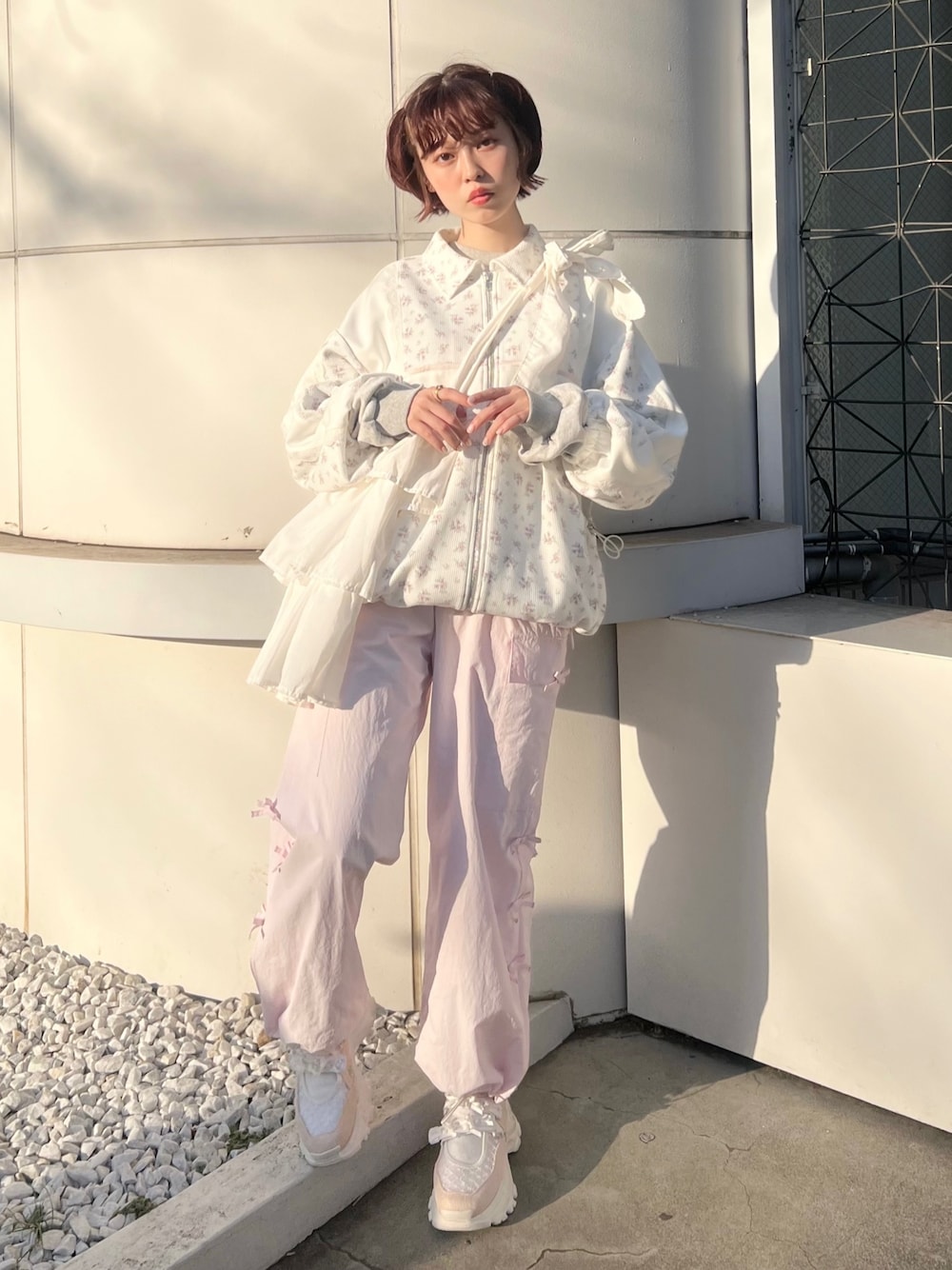 ピンク系のジャージ、ピンク系のカーゴパンツ、ピンク系のスニーカーを着用したレディースの冬コーディネートの1枚目の写真