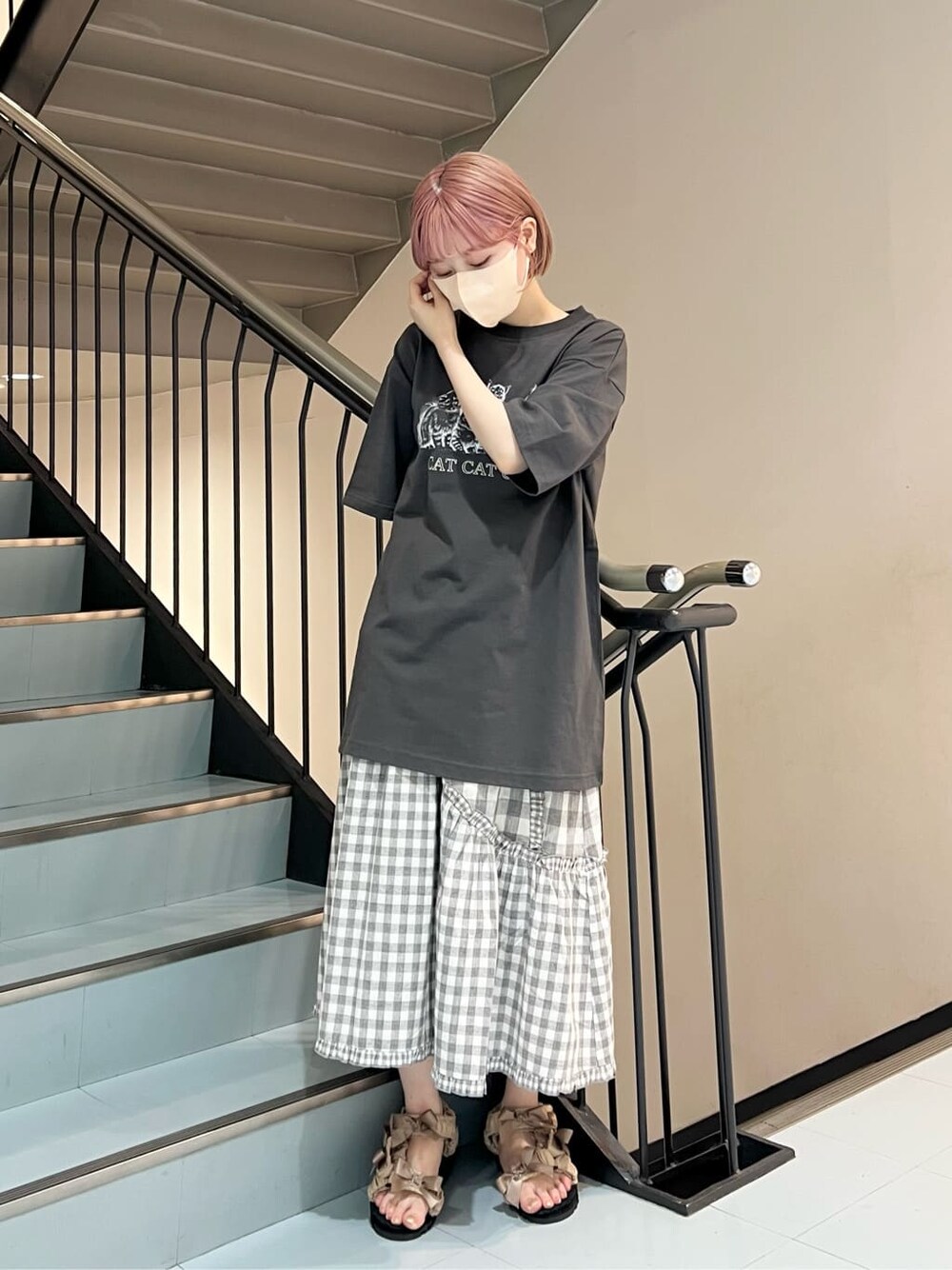 グレー系のスカート、ベージュ系のサンダル、グレー系のTシャツ/カットソーを着用したレディースの夏コーディネートの1枚目の写真