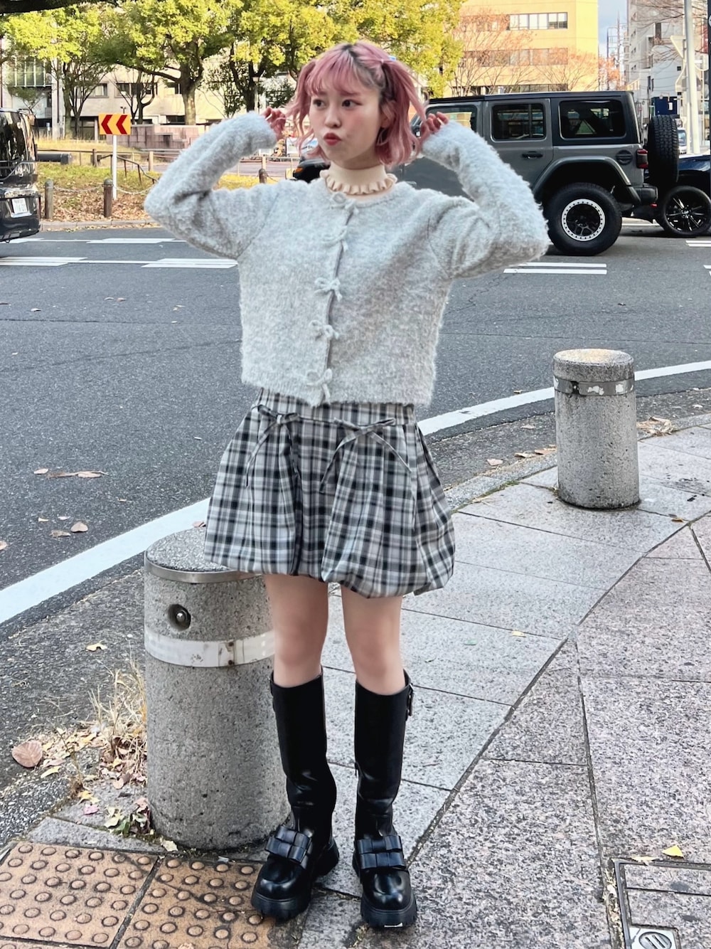 グレー系のカーディガン/ボレロ、ホワイト系のニット/セーター、グレー系のスカートを着用したレディースの冬コーディネートの1枚目の写真