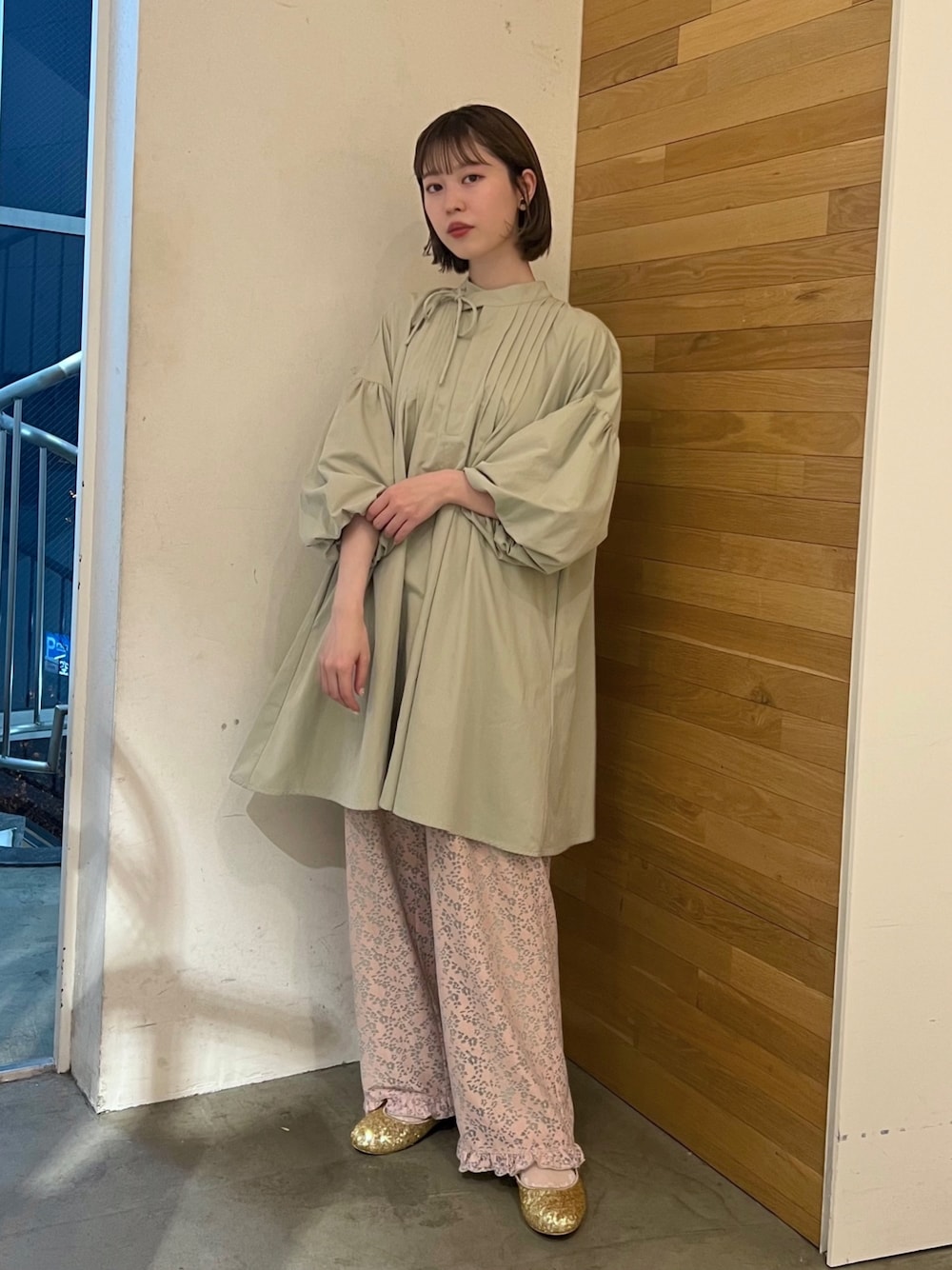 ピンク系のその他パンツ、ゴールド系のパンプス、グリーン系のワンピースを着用したレディースの春コーディネートの1枚目の写真