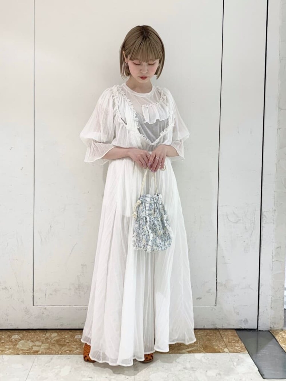 オレンジ系のパンプス、ホワイト系のTシャツ/カットソー、ブルー系のハンドバッグを着用したレディースの春コーディネートの1枚目の写真