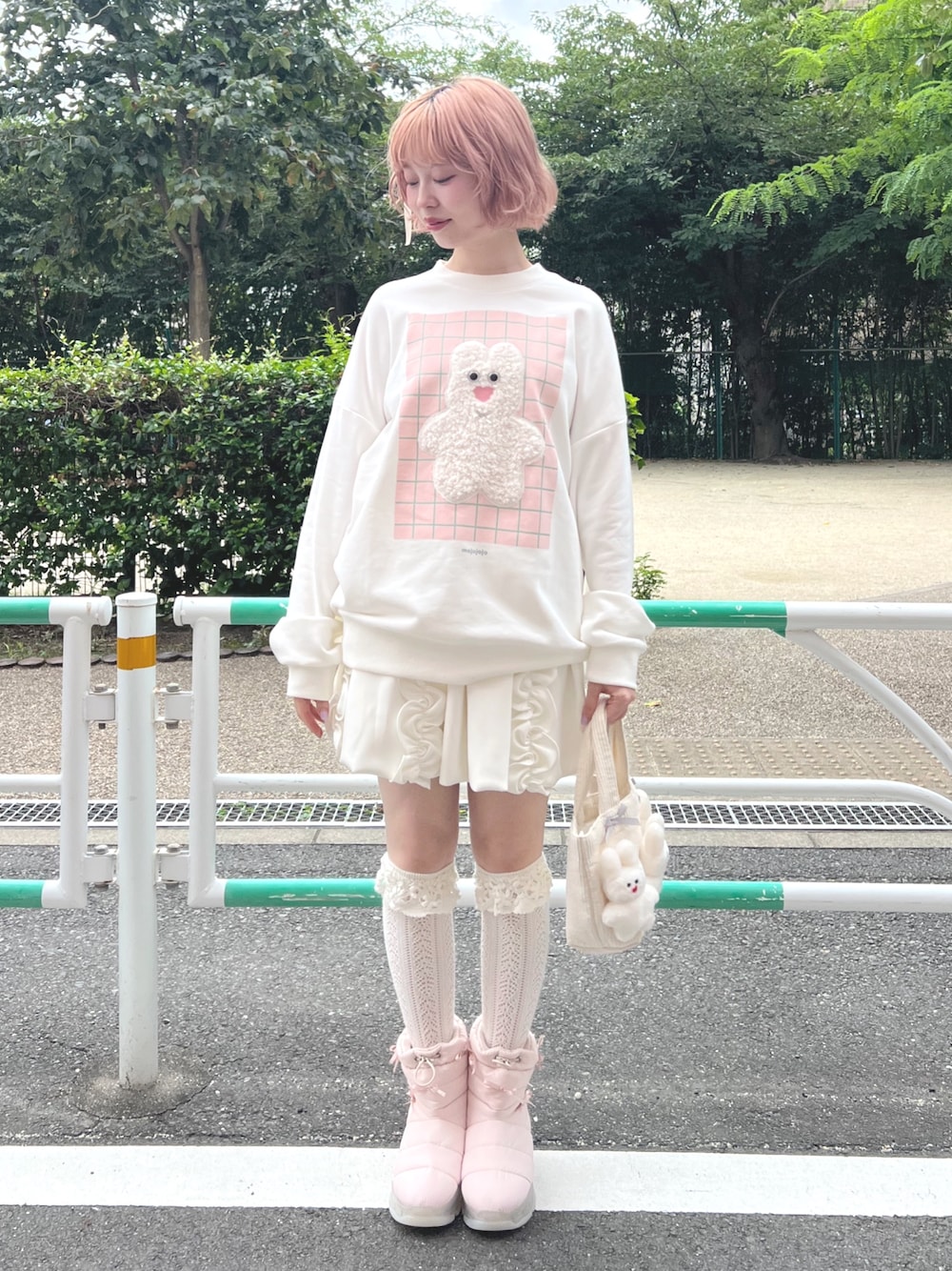 ホワイト系のスカート、ピンク系のブーツ、ホワイト系のスウェットを着用したレディースの秋コーディネートの1枚目の写真