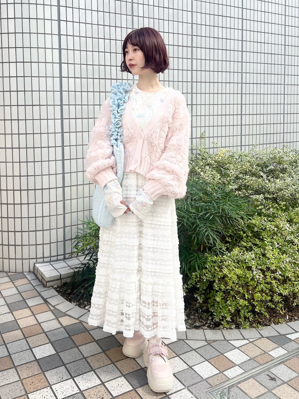 ホワイト系のスカート、ホワイト系のTシャツ/カットソー、ピンク系のスニーカーを着用したレディースの秋コーディネートの1枚目の写真