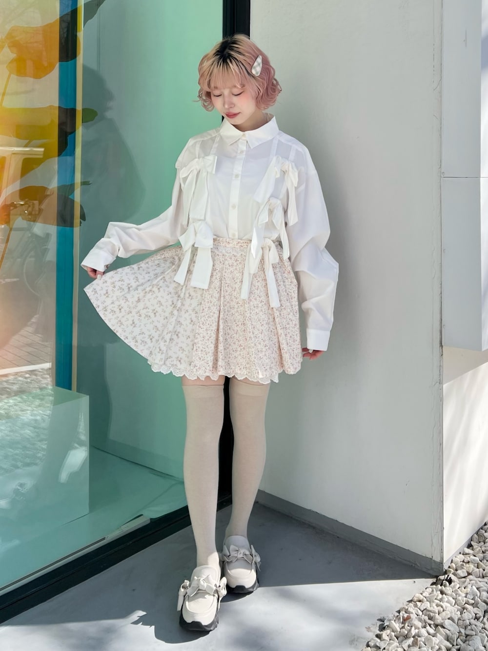 ホワイト系のシャツ/ブラウス、ピンク系のスカート、ホワイト系のスニーカーを着用したレディースの冬コーディネートの1枚目の写真