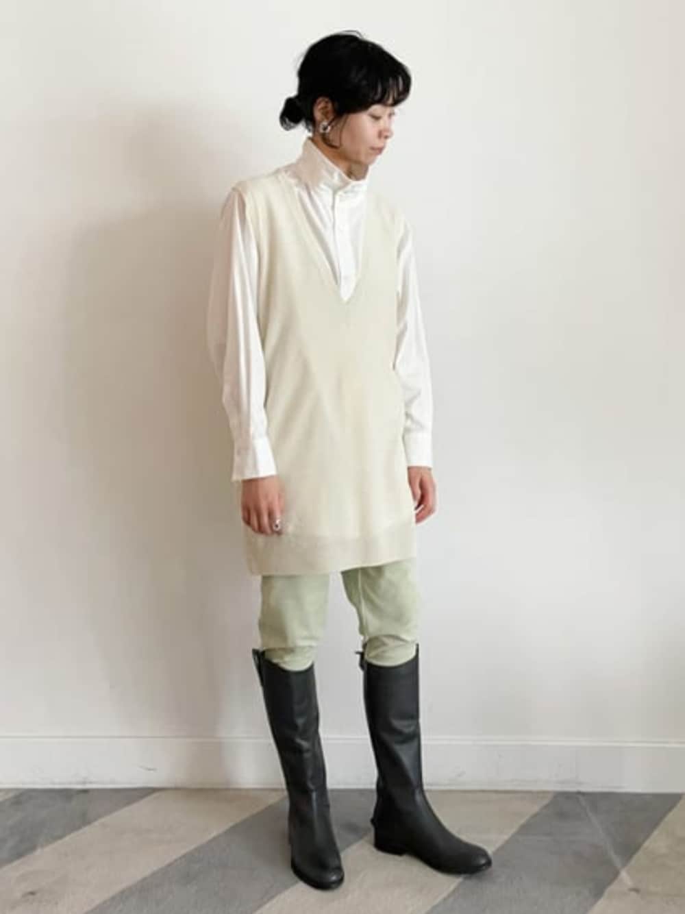 グレー系のブーツ、ホワイト系のニット/セーター、ホワイト系のシャツ/ブラウスを着用したレディースの冬コーディネートの1枚目の写真
