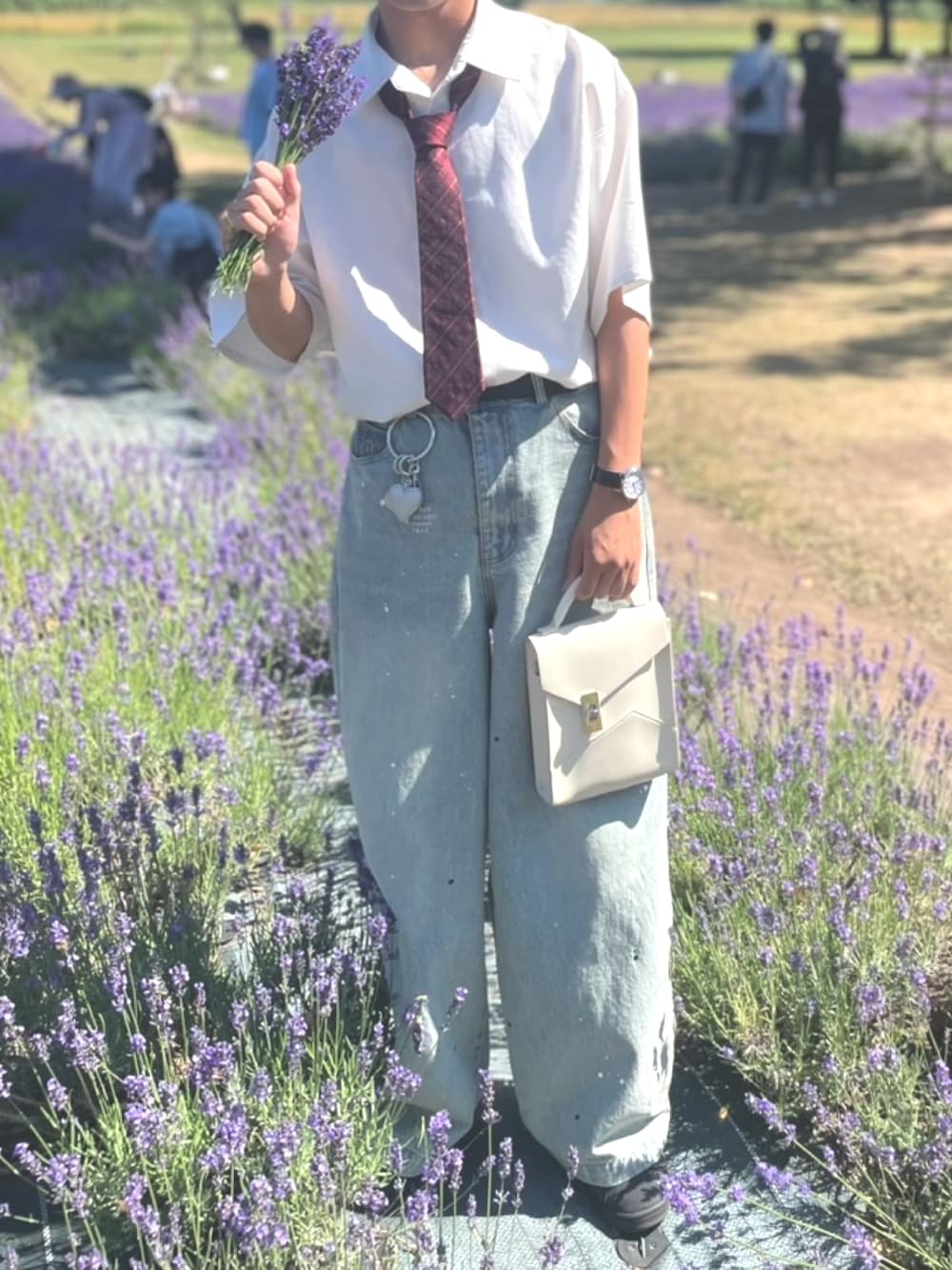 ホワイト系のショルダーバッグ、ブルー系のデニムパンツ、ブラック系のスニーカーを着用したメンズの夏コーディネートの1枚目の写真