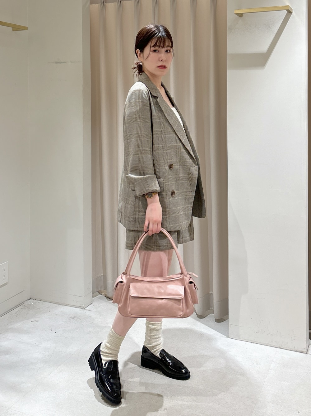 グレー系のテーラードジャケット、グレー系のその他パンツ、ピンク系のショルダーバッグを着用したレディースの春コーディネートの1枚目の写真