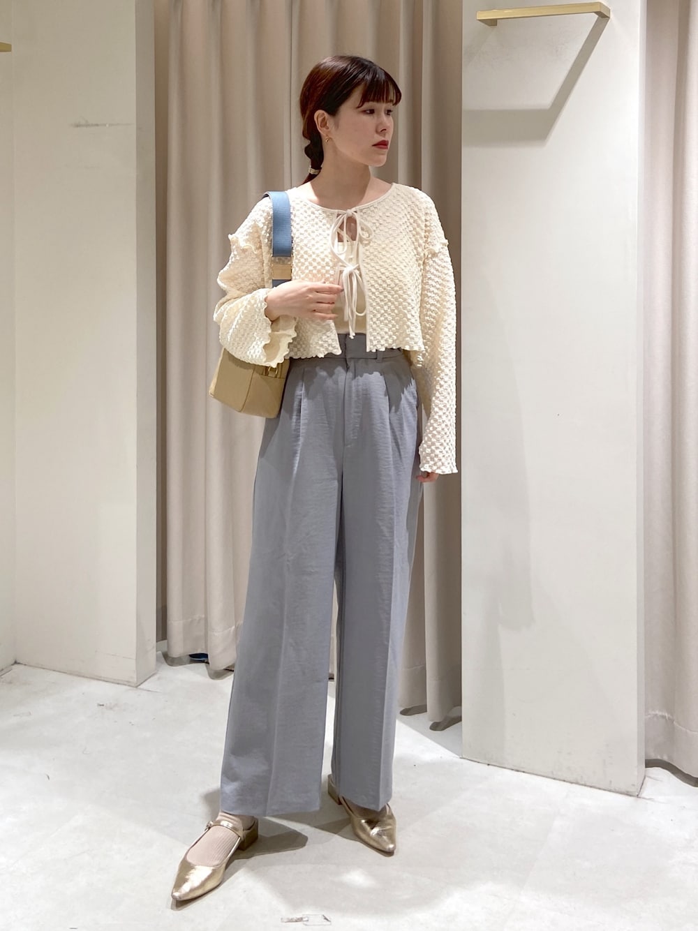ホワイト系のカーディガン/ボレロ、ホワイト系のキャミソール、グレー系のスラックスを着用したレディースの春コーディネートの1枚目の写真