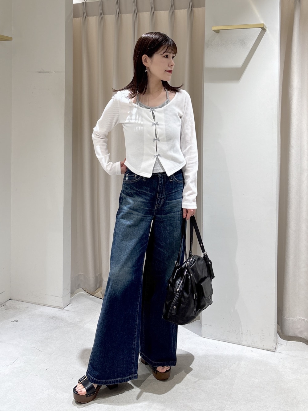 ホワイト系のTシャツ/カットソー、ブルー系のデニムパンツ、ブラック系のサンダルを着用したレディースの春コーディネートの1枚目の写真