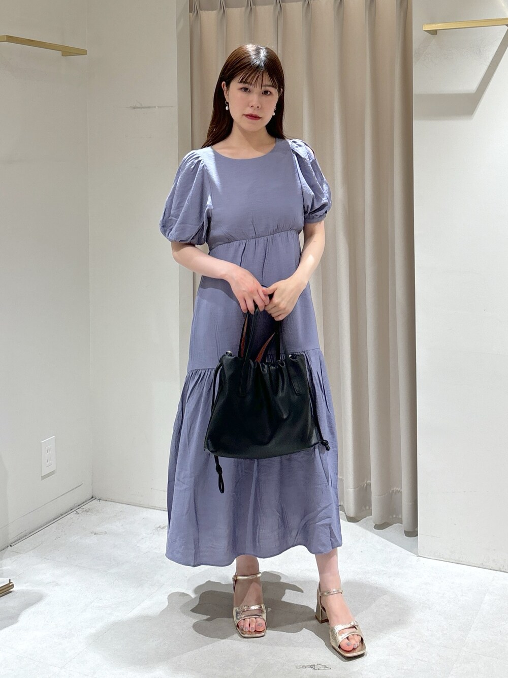 ブルー系のワンピース、ブラック系のハンドバッグ、ゴールド系のサンダルを着用したレディースの夏コーディネートの1枚目の写真