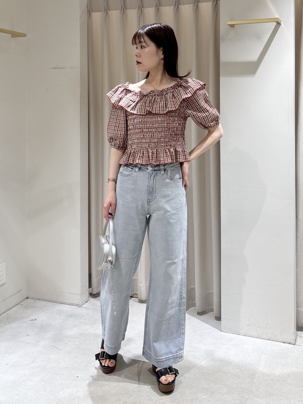 レッド系のシャツ/ブラウス、ブルー系のデニムパンツ、シルバー系のショルダーバッグを着用したレディースの春コーディネートの1枚目の写真