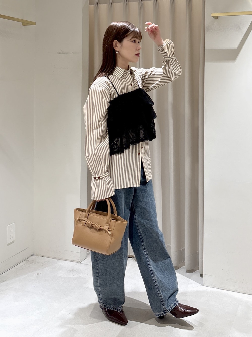 ブラック系のシャツ/ブラウス、ブラウン系のシャツ/ブラウス、ベージュ系のハンドバッグを着用したレディースの冬コーディネートの1枚目の写真