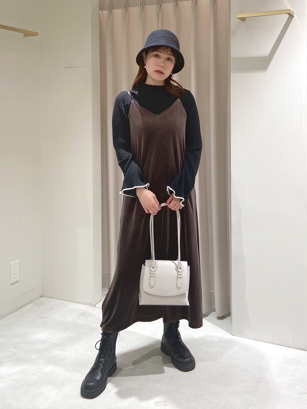 ブラウン系のワンピース、ブラック系のニット/セーター、ホワイト系のショルダーバッグを着用したレディースの冬コーディネートの1枚目の写真