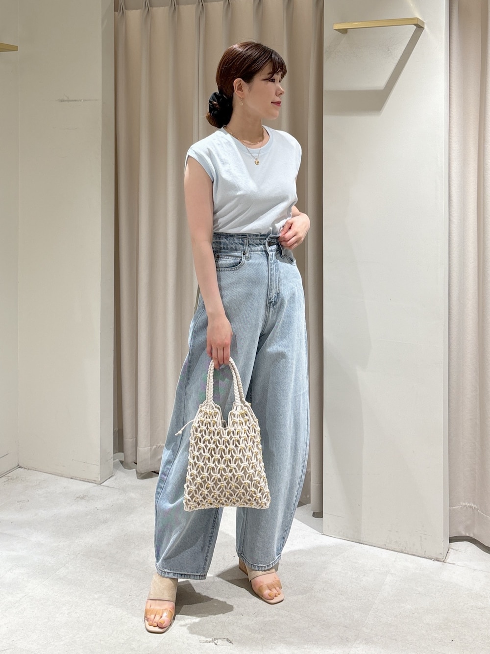 ブルー系のTシャツ/カットソー、ブルー系のデニムパンツ、ホワイト系のハンドバッグを着用したレディースの春コーディネートの1枚目の写真