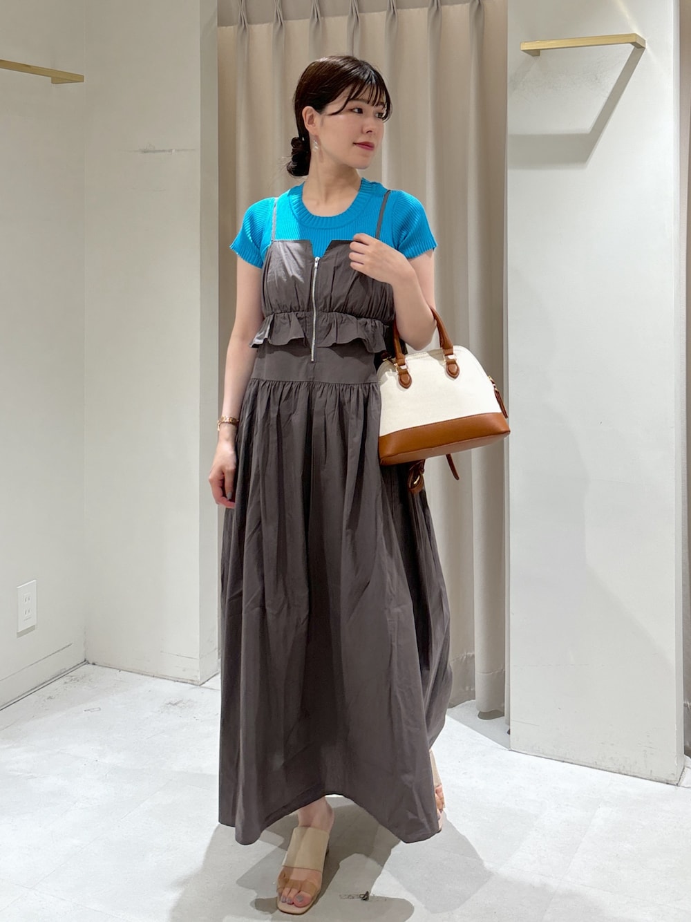 グレー系のワンピース、ブルー系のニット/セーター、ブラウン系のショルダーバッグを着用したレディースの夏コーディネートの1枚目の写真