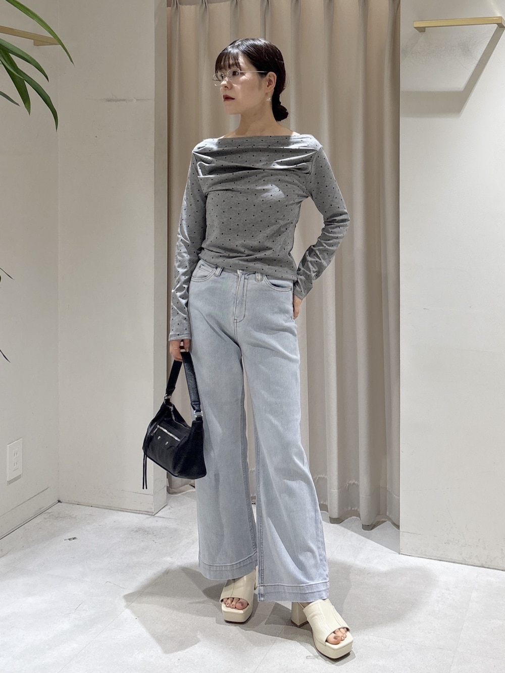 ブルー系のデニムパンツ、ブラック系のショルダーバッグ、ホワイト系のサンダルを着用したレディースの夏コーディネートの1枚目の写真