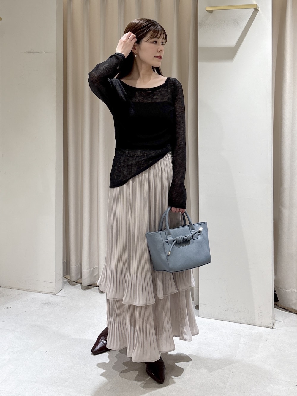 ブラック系のTシャツ/カットソー、ブラック系のキャミソール、ブルー系のハンドバッグを着用したレディースの冬コーディネートの1枚目の写真