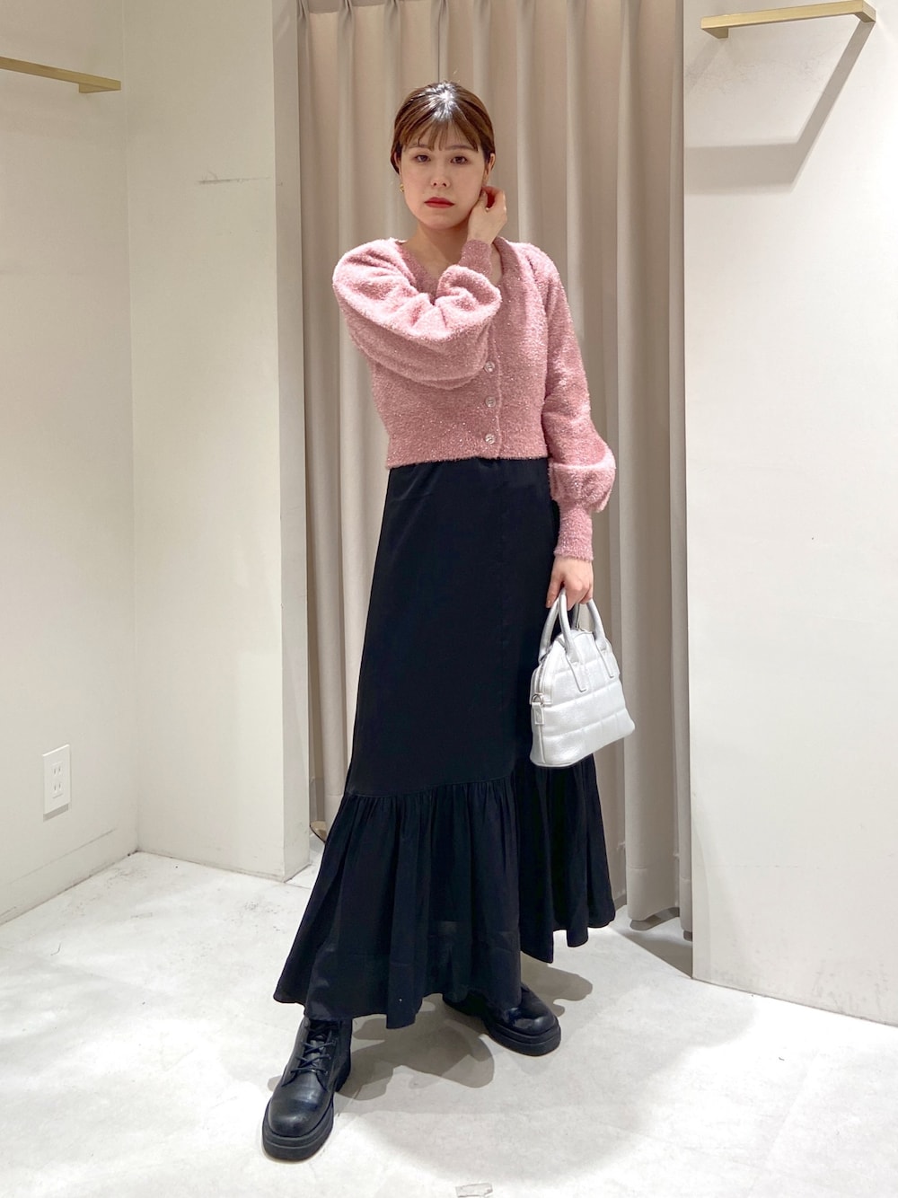 ピンク系のニット/セーター、ブラック系のワンピース、シルバー系のショルダーバッグを着用したレディースの冬コーディネートの1枚目の写真