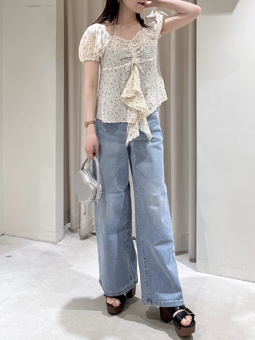 ホワイト系のシャツ/ブラウス、シルバー系のショルダーバッグ、ブルー系のデニムパンツを着用したレディースの春コーディネートの1枚目の写真