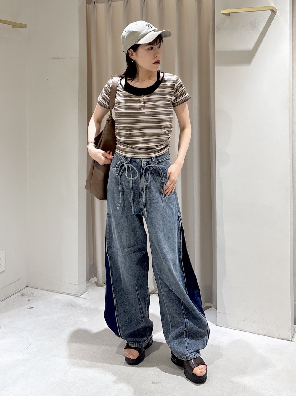 ブラウン系のTシャツ/カットソー、ブルー系のデニムパンツ、ブラウン系のトートバッグを着用したレディースの夏コーディネートの1枚目の写真
