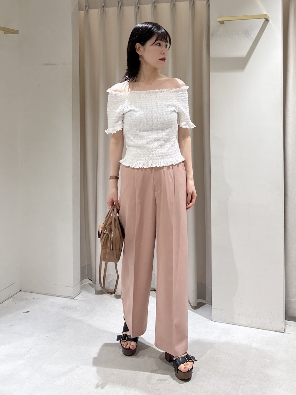 ホワイト系のTシャツ/カットソー、ピンク系のスラックス、ブラウン系のハンドバッグを着用したレディースの夏コーディネートの1枚目の写真