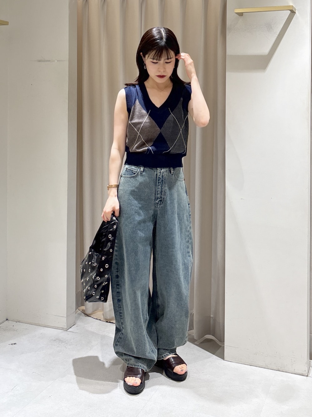ブルー系のニット/セーター、ブルー系のデニムパンツ、ブラック系のショルダーバッグを着用したレディースの夏コーディネートの1枚目の写真
