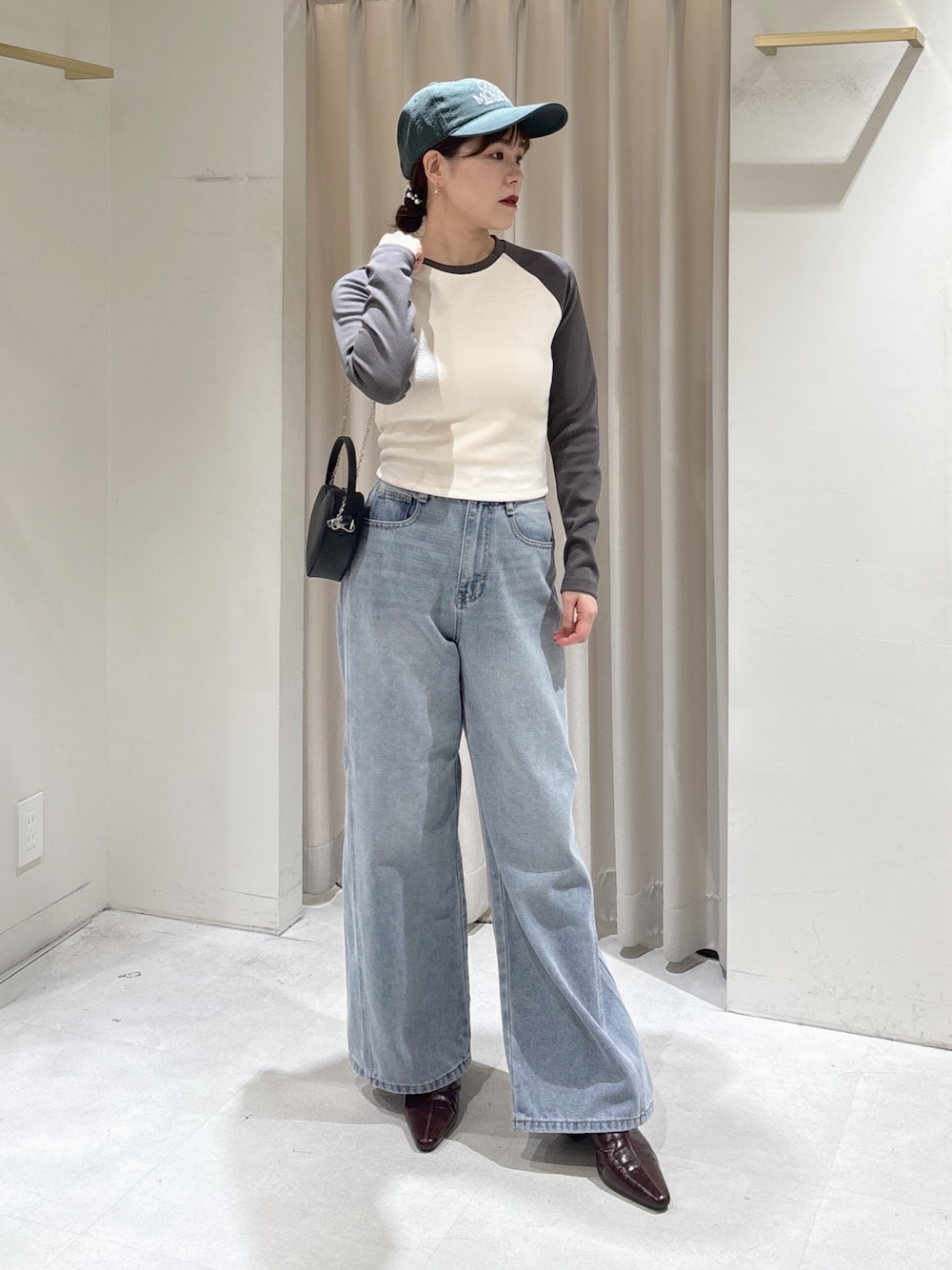 ホワイト系のTシャツ/カットソー、ブルー系のデニムパンツ、ブラック系のショルダーバッグを着用したレディースの冬コーディネートの1枚目の写真