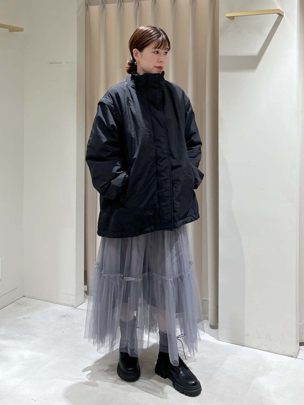 ブラック系のダウンジャケット/コート、グレー系のスカート、ブラック系のブーツを着用したレディースの秋コーディネートの1枚目の写真