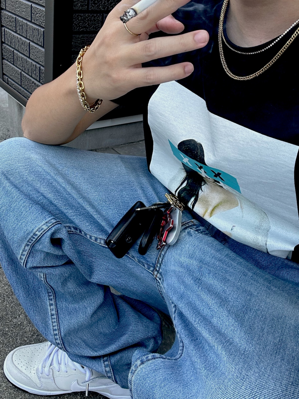 ブラック系のTシャツ/カットソー、ブルー系のデニムパンツ、ホワイト系のスニーカーを着用したメンズの夏コーディネートの1枚目の写真