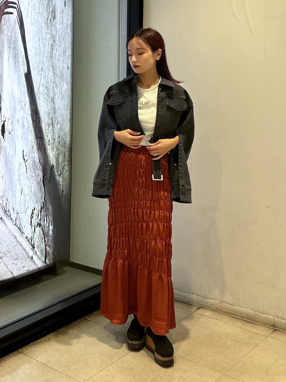 ブラック系のデニムジャケット、ホワイト系のTシャツ/カットソー、オレンジ系のスカートを着用したレディースの夏コーディネートの1枚目の写真